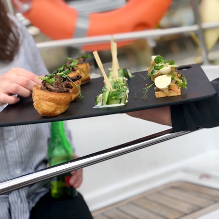 Passenger being offered canapes whilst sailing in Auckland
